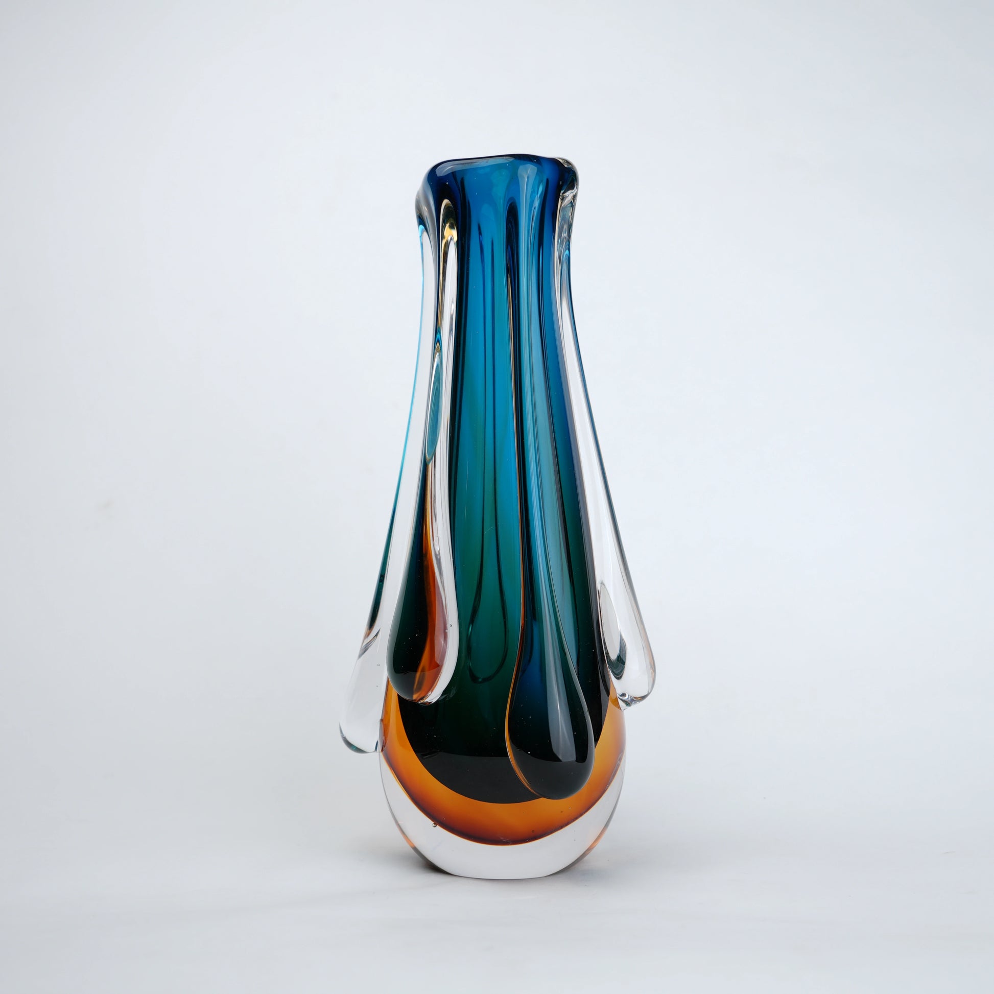 Aqua teal glass vase with amber base and flowing drip design in clear glass