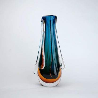 Aqua teal glass vase with amber base and flowing drip design in clear glass