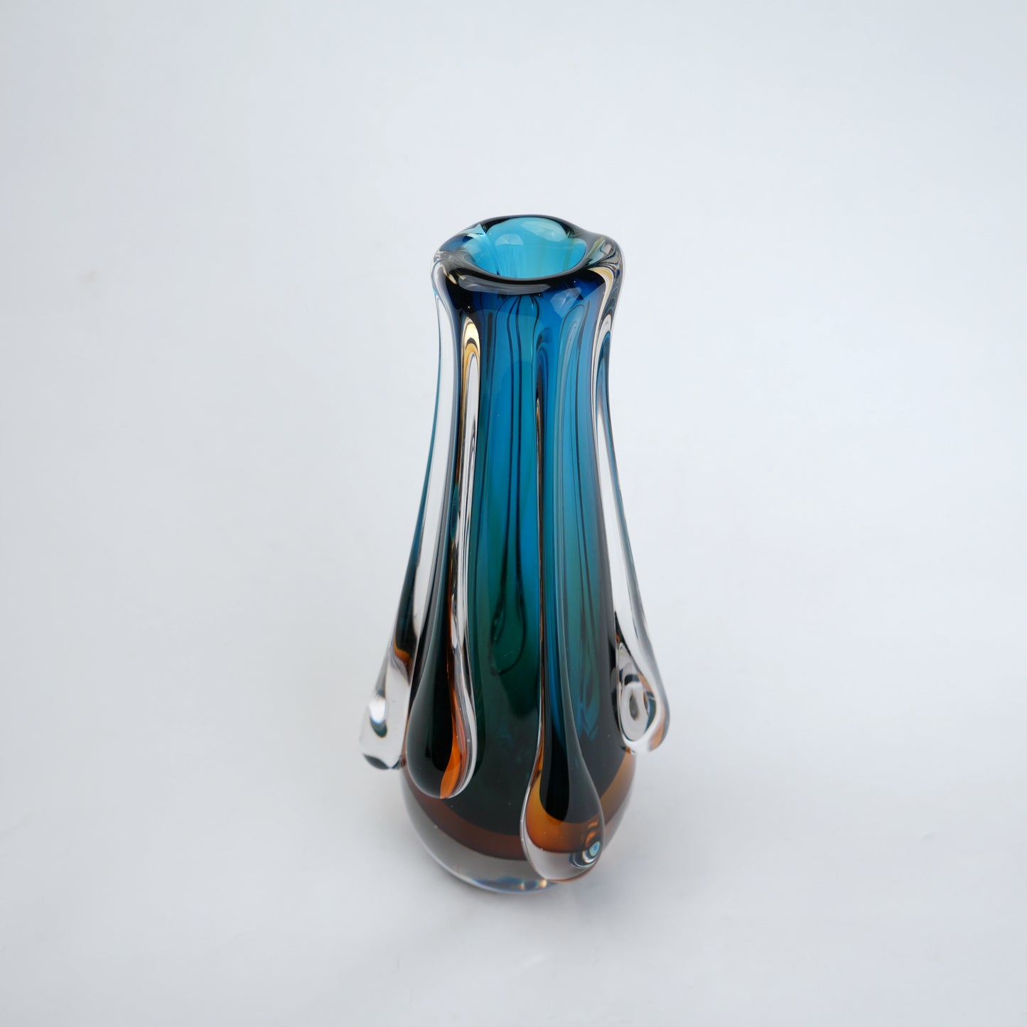 Aqua teal glass vase with amber base and flowing drip design in clear glass