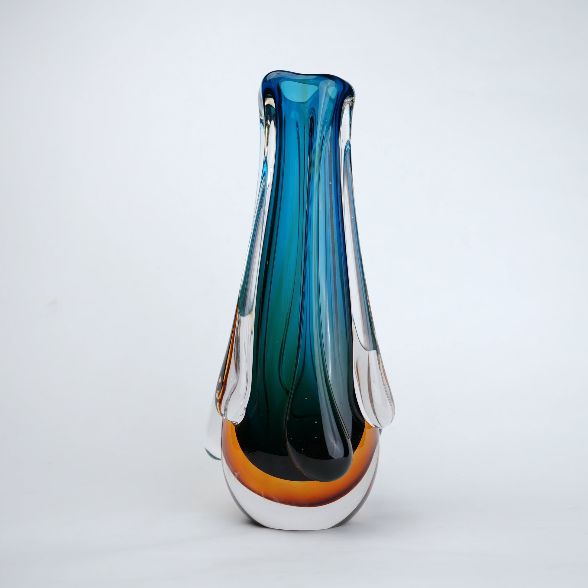 Aqua teal glass vase with amber base and flowing drip design in clear glass