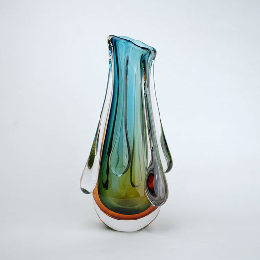 Green and teal glass vase with amber base and flowing drip design in clear glass