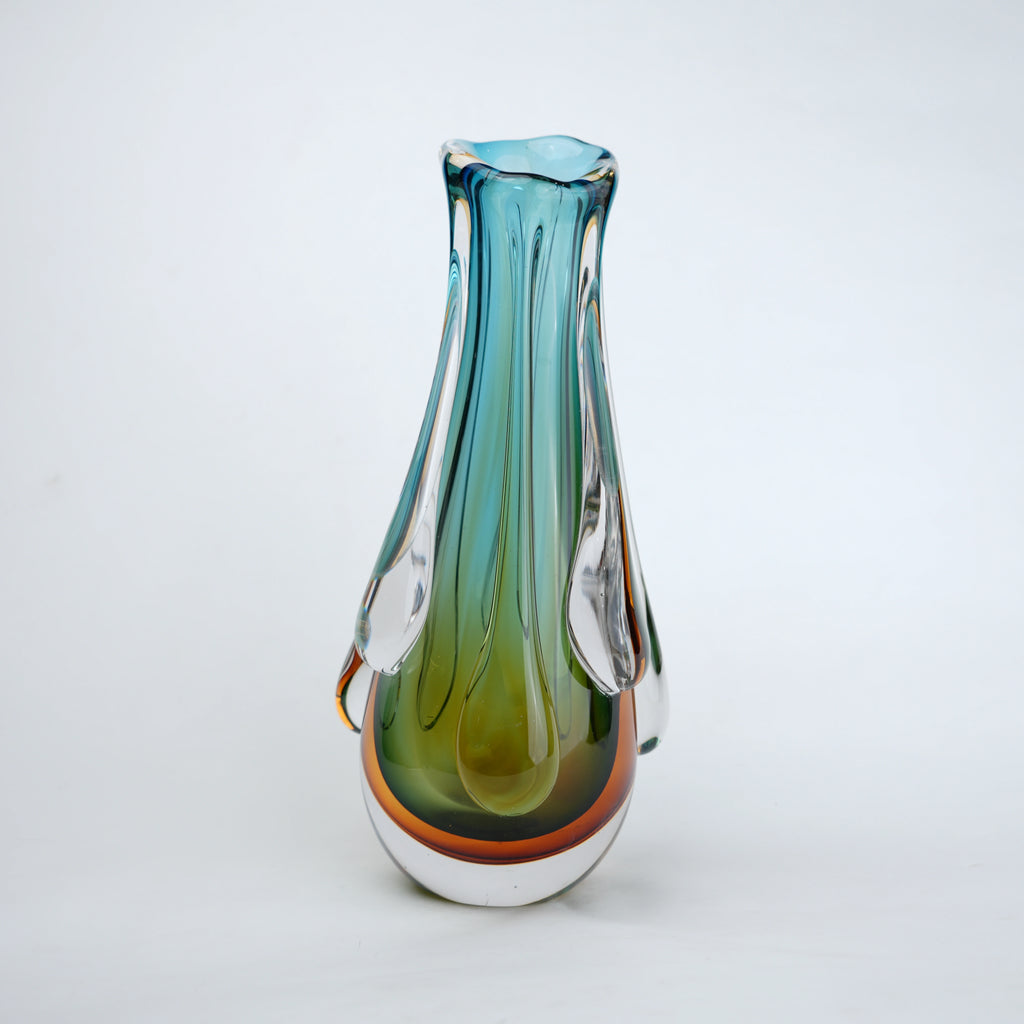 Green and teal glass vase with amber base and flowing drip design in clear glass