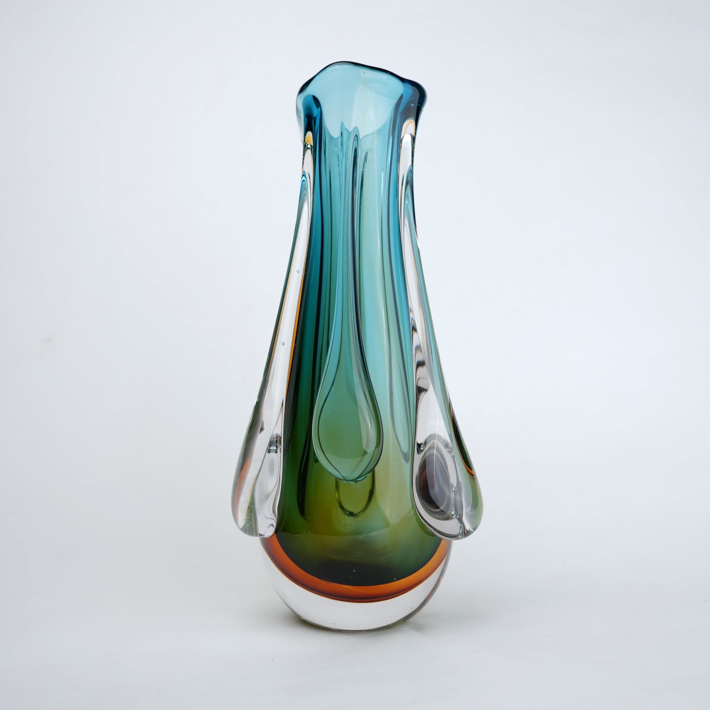 Green and teal glass vase with amber base and flowing drip design in clear glass