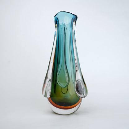 Green and teal glass vase with amber base and flowing drip design in clear glass