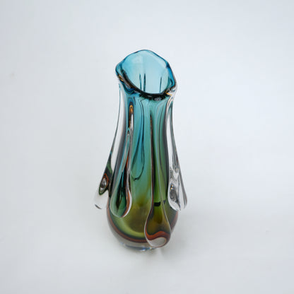 Green and teal glass vase with amber base and flowing drip design in clear glass