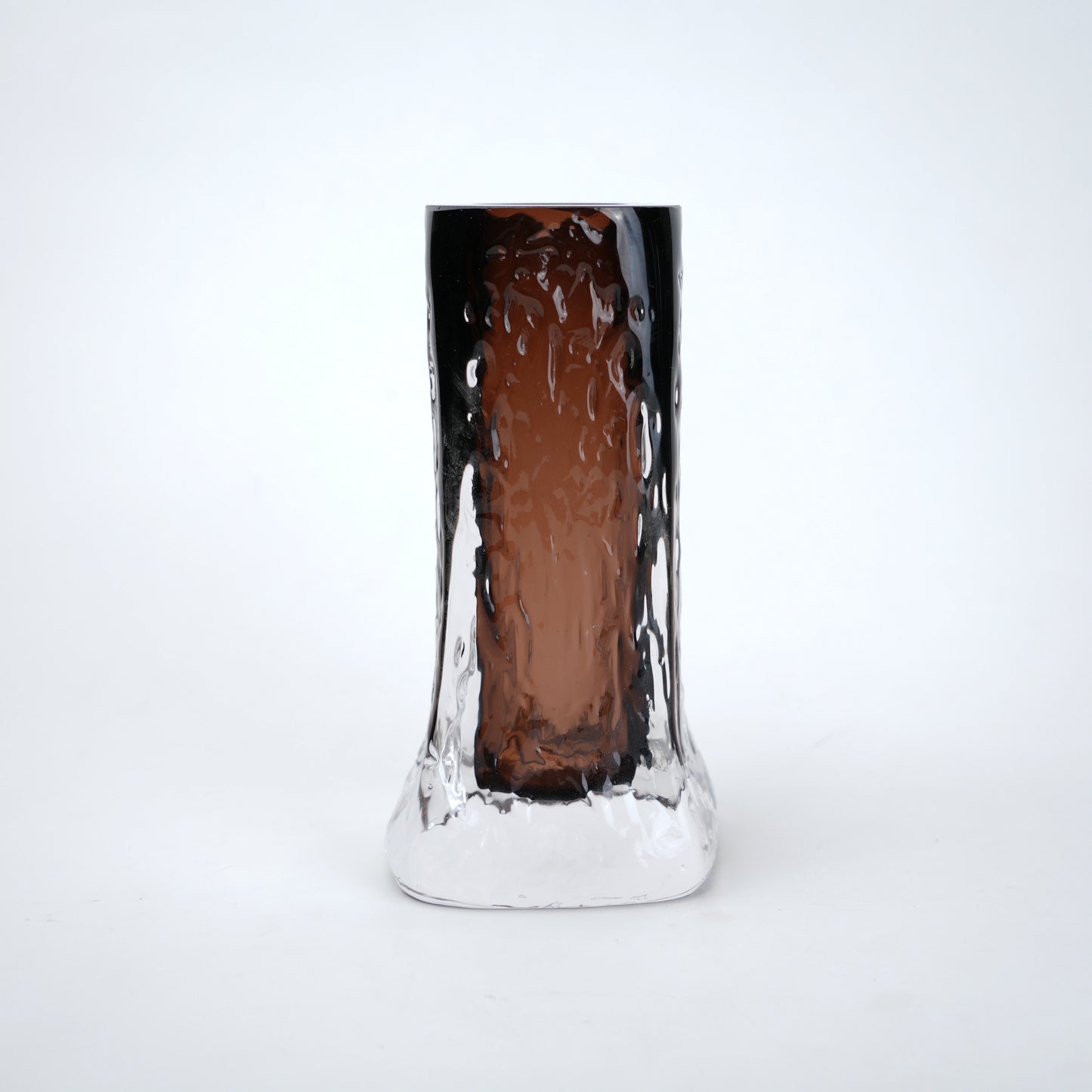 Tall, cylindrical glass with textured surface on a white background
