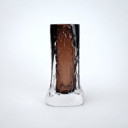 Tall, cylindrical glass with textured surface on a white background