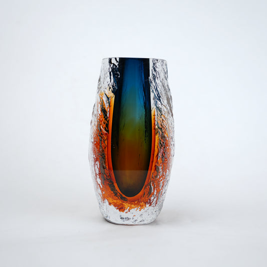 Blue and amber glass vase with textured clear outer layer and cylindrical design