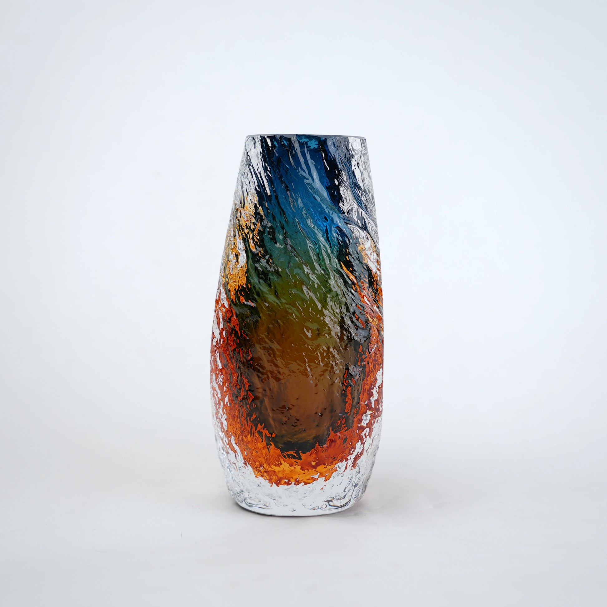 Blue and amber glass vase with textured clear outer layer and cylindrical design
