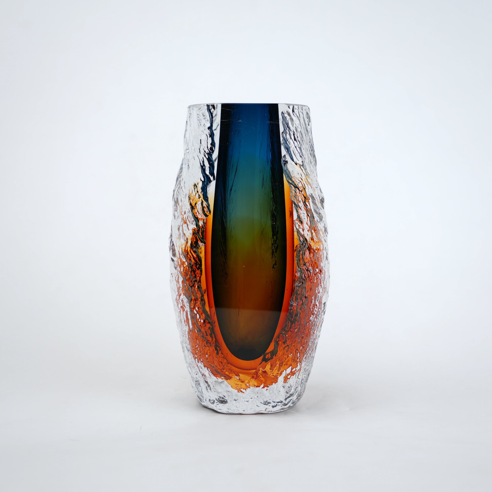Blue and amber glass vase with textured clear outer layer and cylindrical design