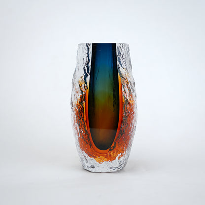 Blue and amber glass vase with textured clear outer layer and cylindrical design