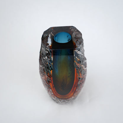 Blue and amber glass vase with textured clear outer layer and cylindrical design