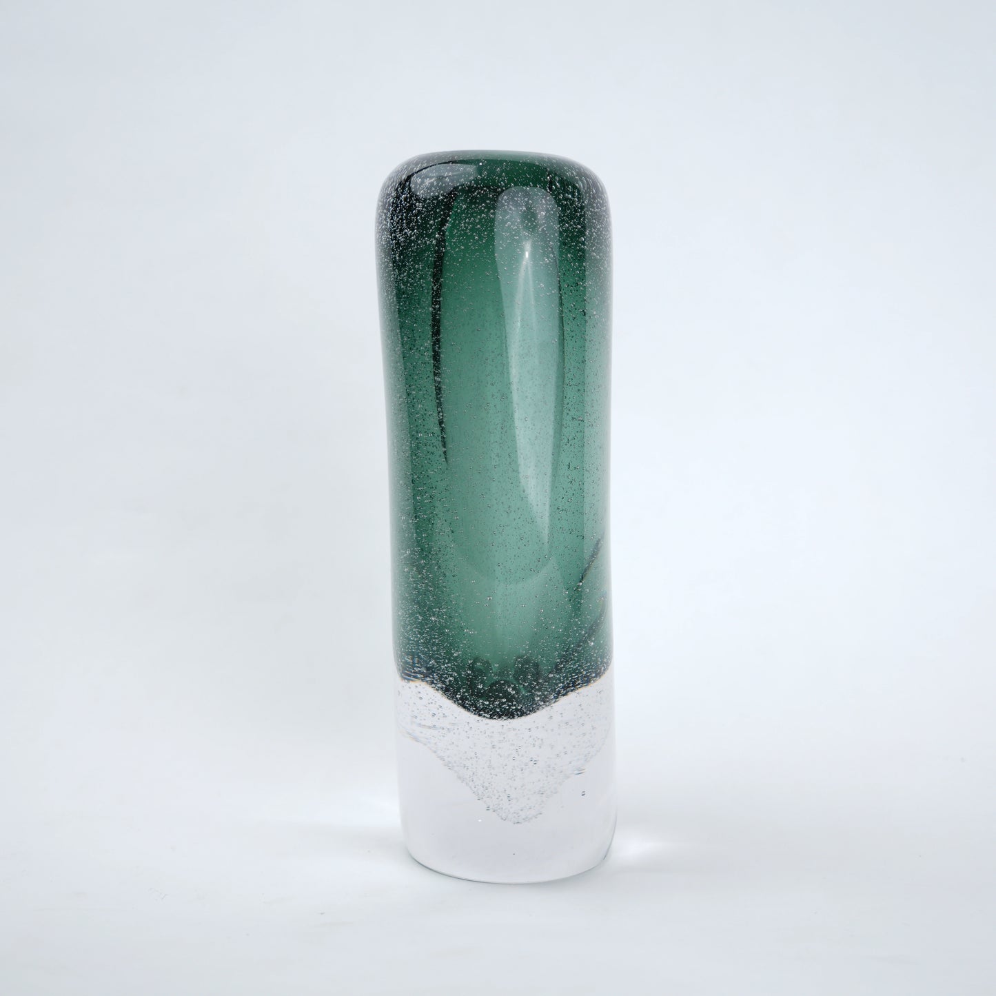 Tall green and clear glass vase on a light gray background