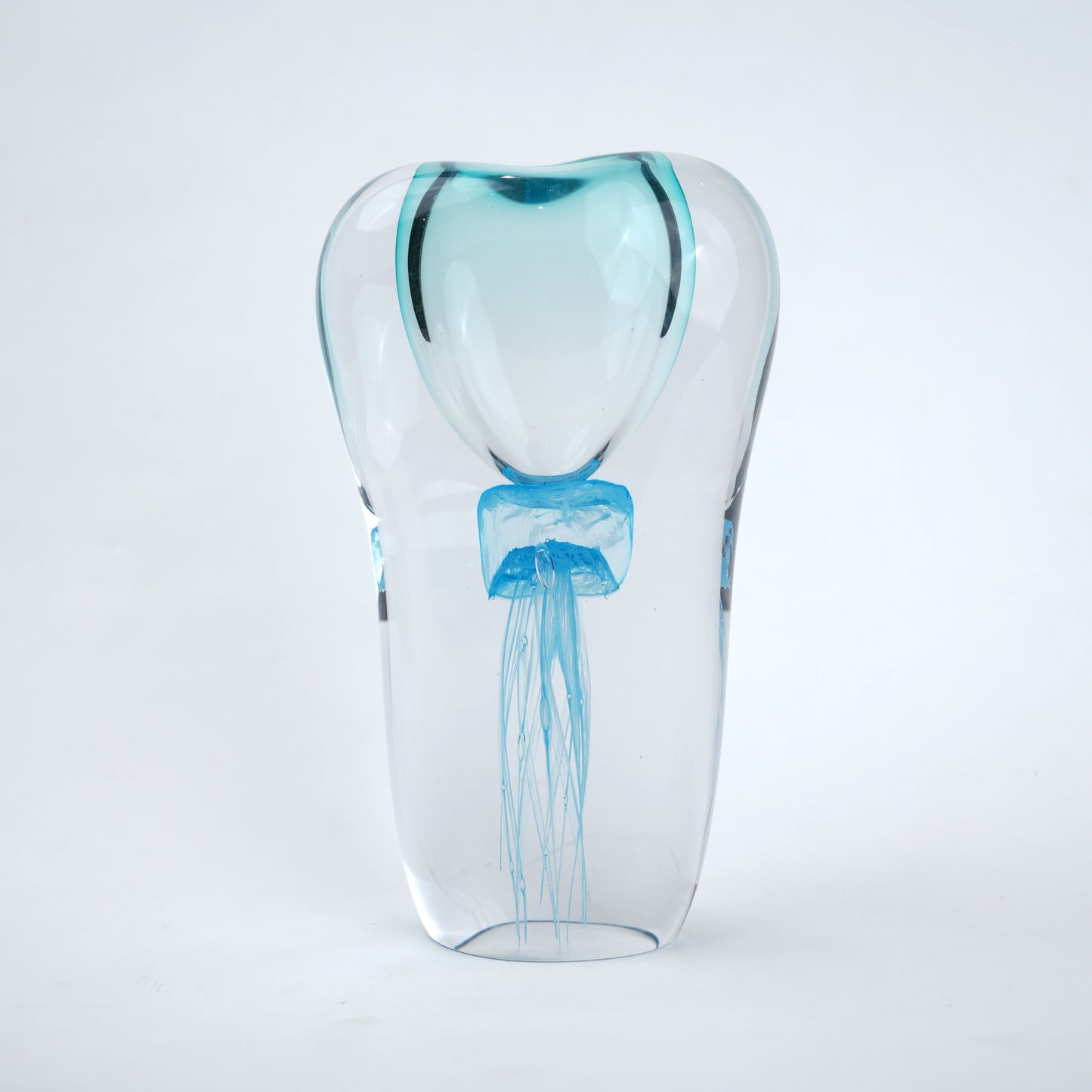 Decorative art glass vase with blue center encased inside clear glass body.