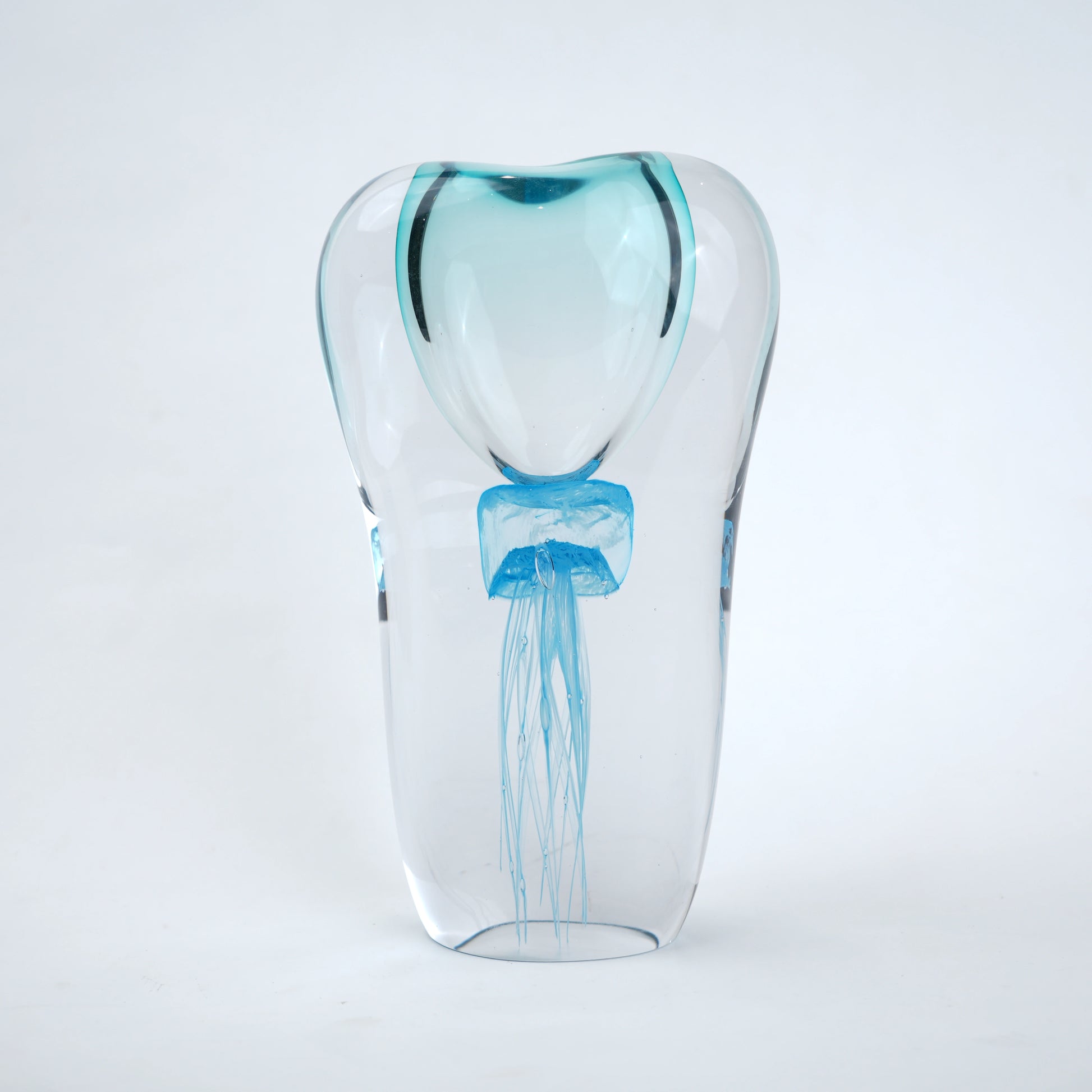 Decorative art glass vase with blue center encased inside clear glass body.