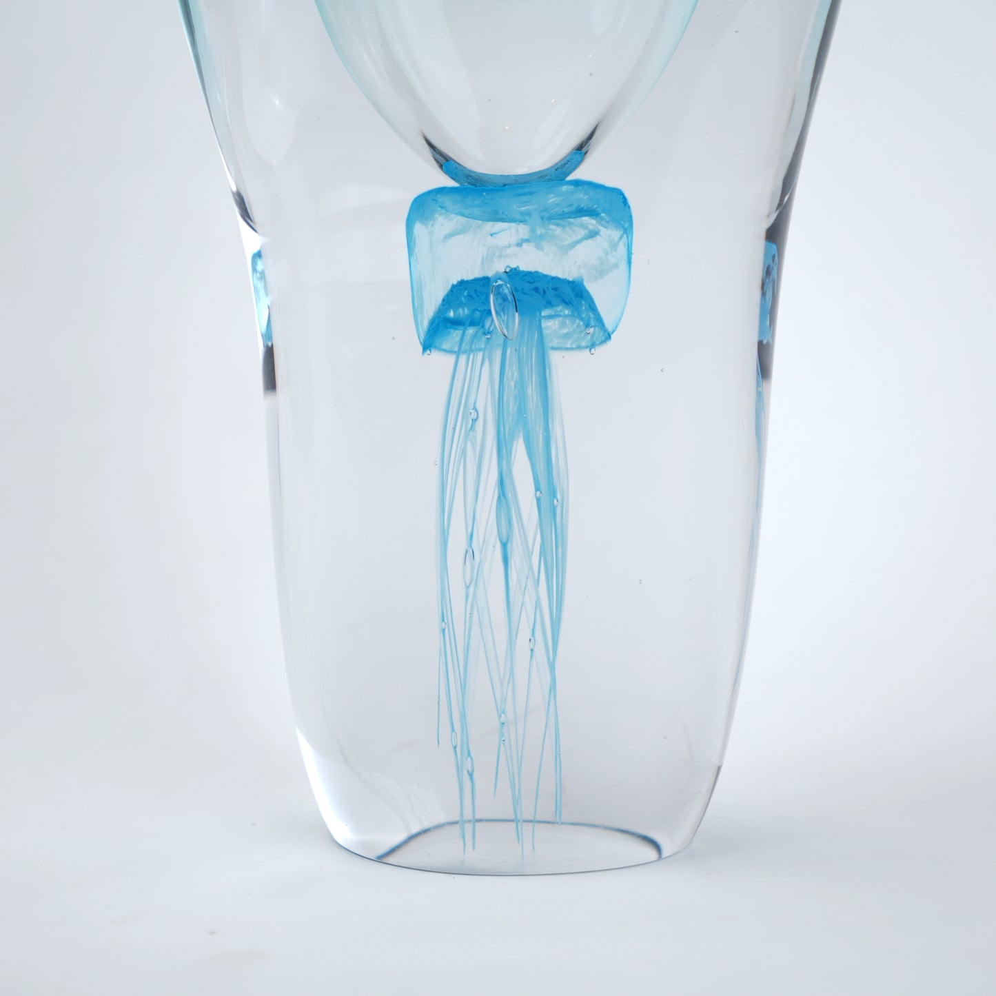 Decorative art glass vase with blue center encased inside clear glass body.