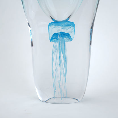 Decorative art glass vase with blue center encased inside clear glass body.