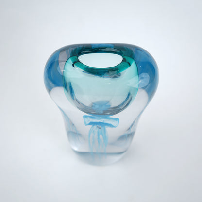 Decorative art glass vase with blue center encased inside clear glass body.