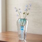 Decorative art glass vase with blue center encased inside clear glass body.