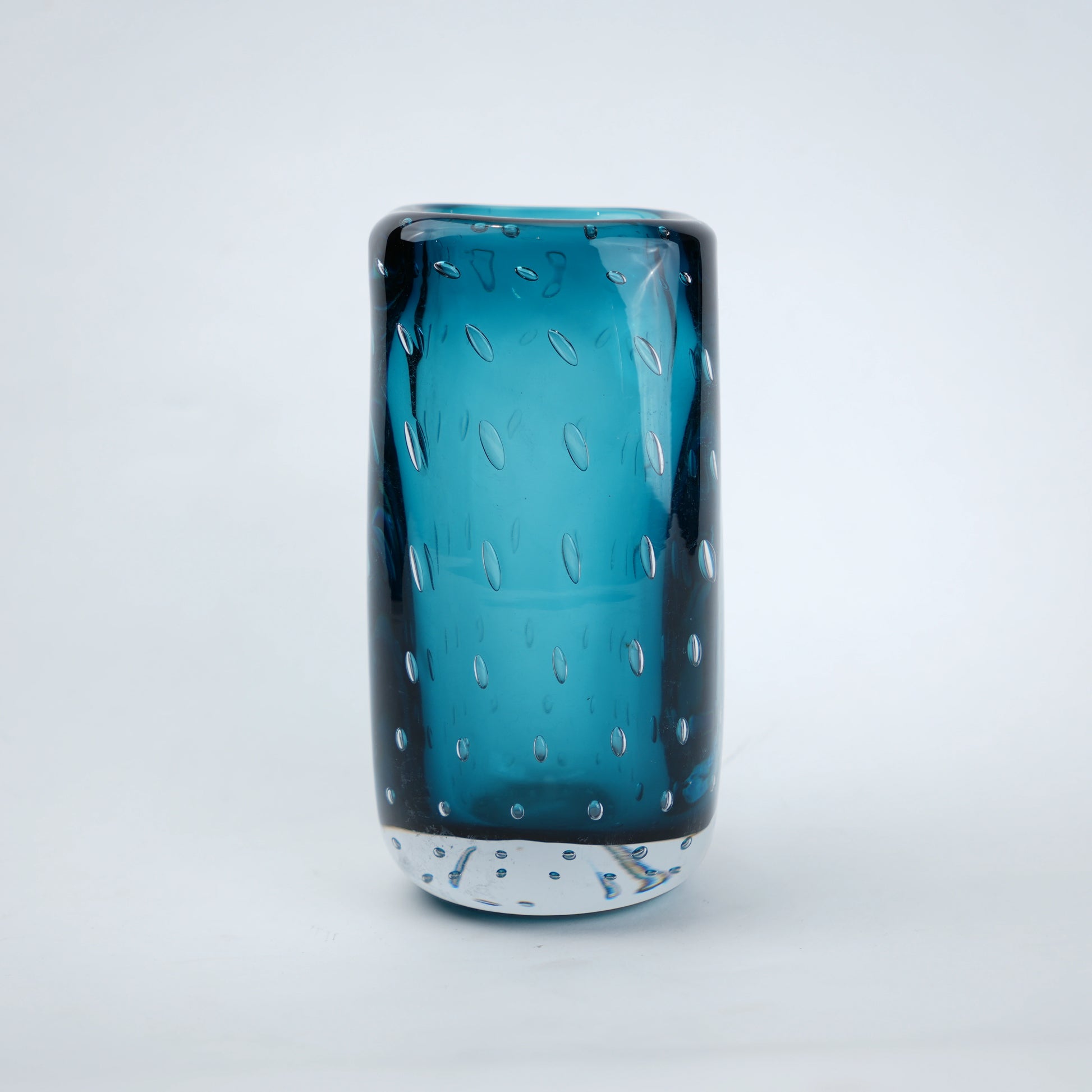 Textured blue art glass decorative vase with cylindrical form and patterned glass surface.