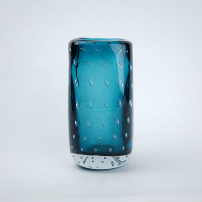 Textured blue art glass decorative vase with cylindrical form and patterned glass surface.