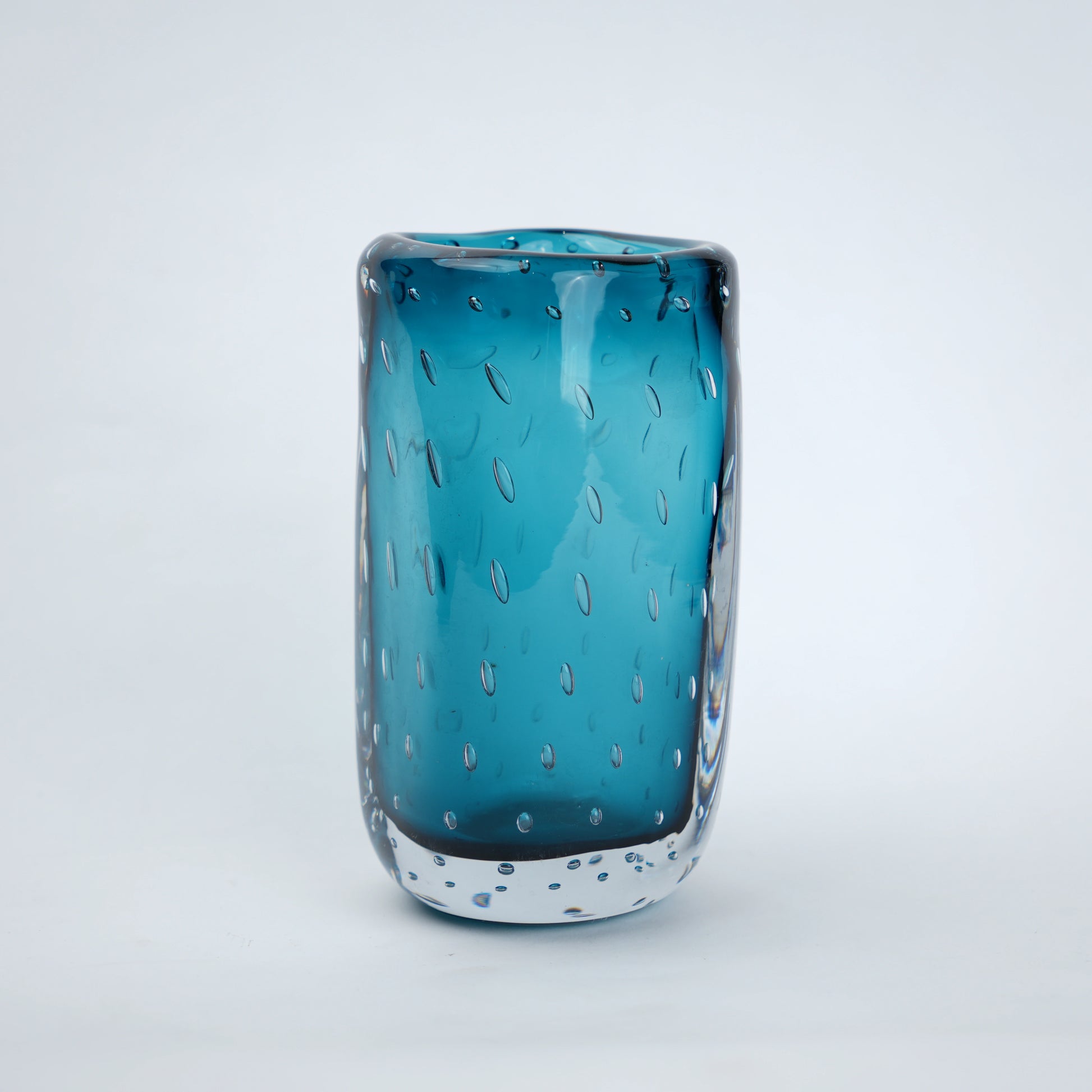 Textured blue art glass decorative vase with cylindrical form and patterned glass surface.