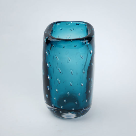 Textured blue art glass decorative vase with cylindrical form and patterned glass surface.