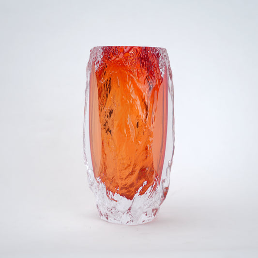 Amber orange art glass decorative vase with clear glass outer body and elongated oval form.