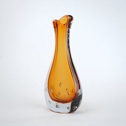 Amber clear art glass decorative vase with layered color center and elongated glass form.