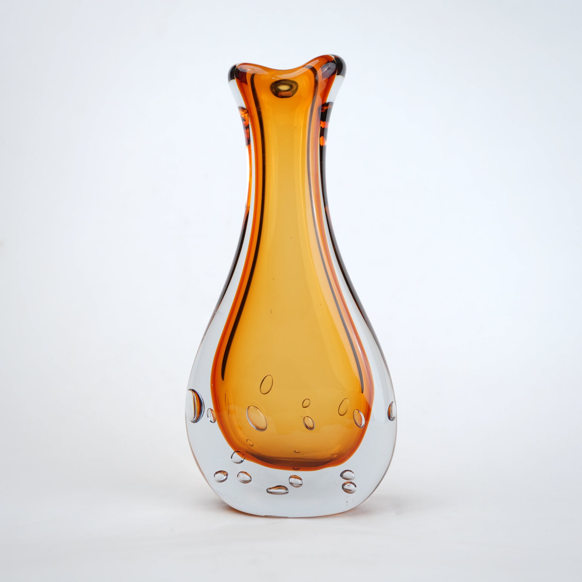 Amber clear art glass decorative vase with layered color center and elongated glass form.
