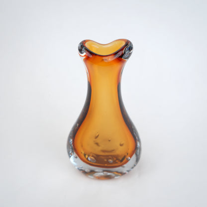 Amber clear art glass decorative vase with layered color center and elongated glass form.
