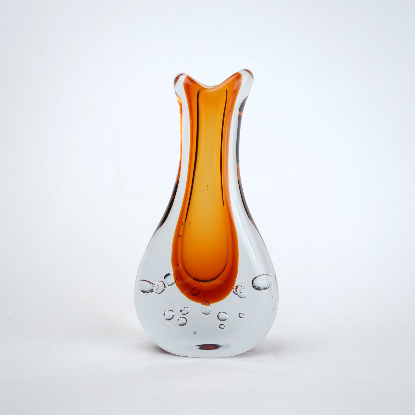 Amber clear art glass decorative vase with layered color center and elongated glass form.