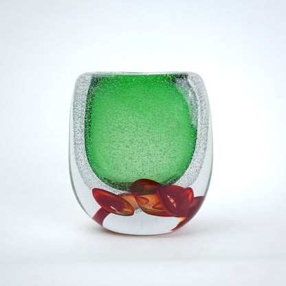 Decorative glass piece with green center and red base on a white background