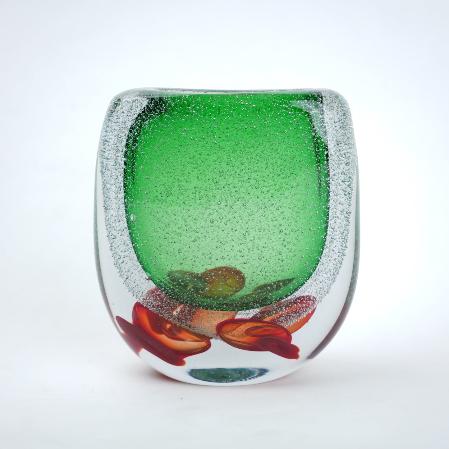 Decorative glass piece with green center and red and brown floral design on a white background