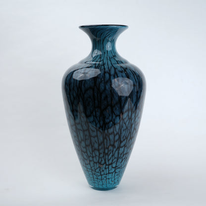 Tall blue glass vase with glossy finish featuring organic vein-like textured patterns and a gradient aqua to deep blue color transition with a flared neck design.