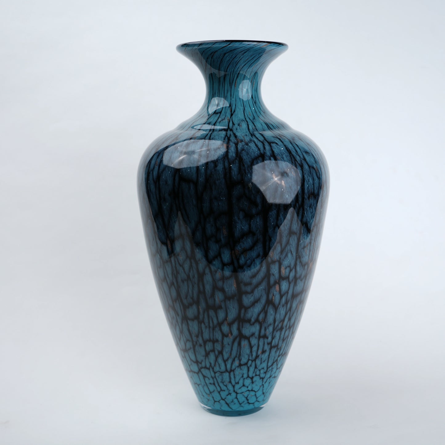Tall blue glass vase with glossy finish featuring organic vein-like textured patterns and a gradient aqua to deep blue color transition with a flared neck design.