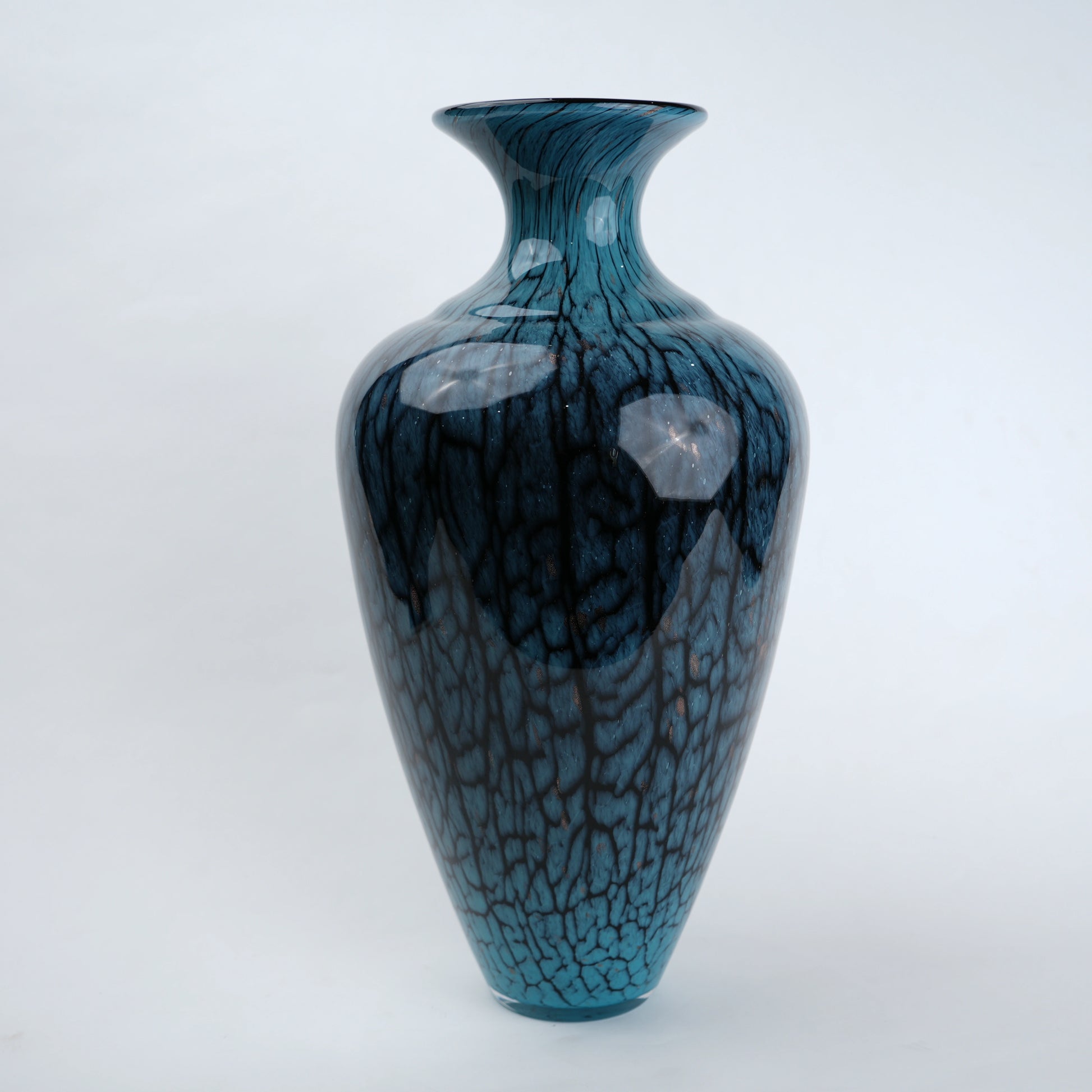 Tall blue glass vase with glossy finish featuring organic vein-like textured patterns and a gradient aqua to deep blue color transition with a flared neck design.