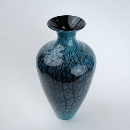 Tall blue glass vase with glossy finish featuring organic vein-like textured patterns and a gradient aqua to deep blue color transition with a flared neck design.