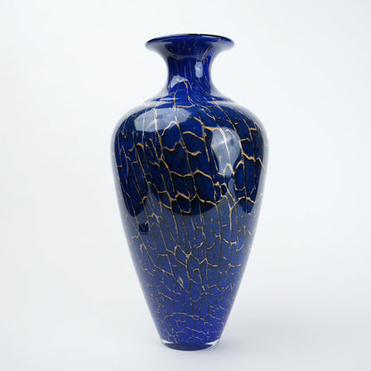 Decorative blue glass vase with deep color tone and fine gold pattern detailing designed for modern home decor