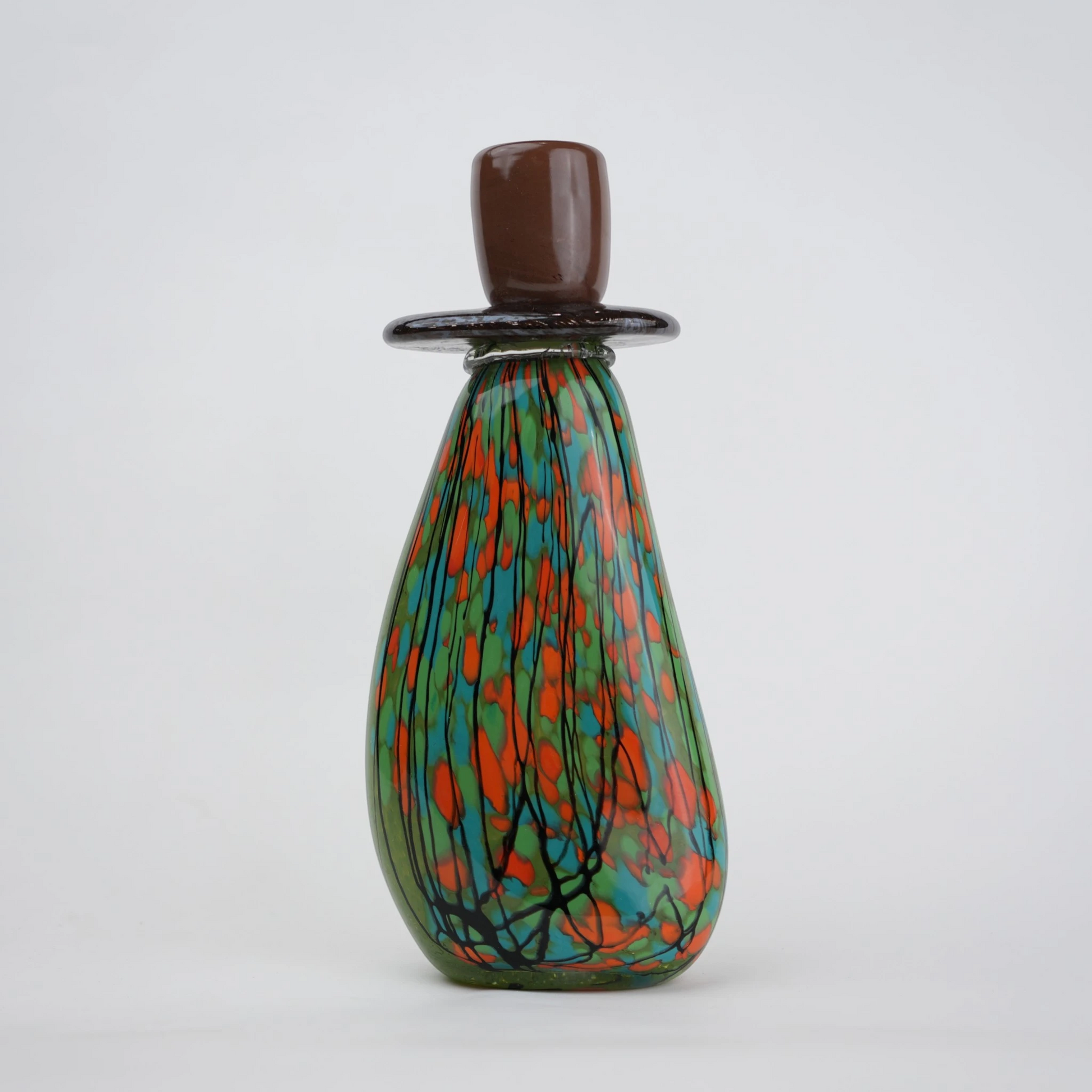 Emerald green decorative glass candle holder with orange and black drip pattern