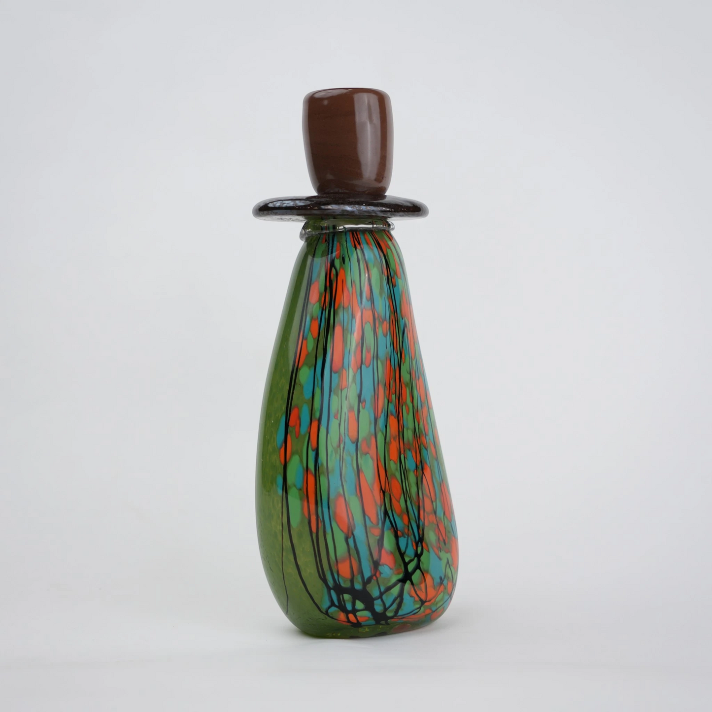 Emerald green decorative glass candle holder with orange and black drip pattern