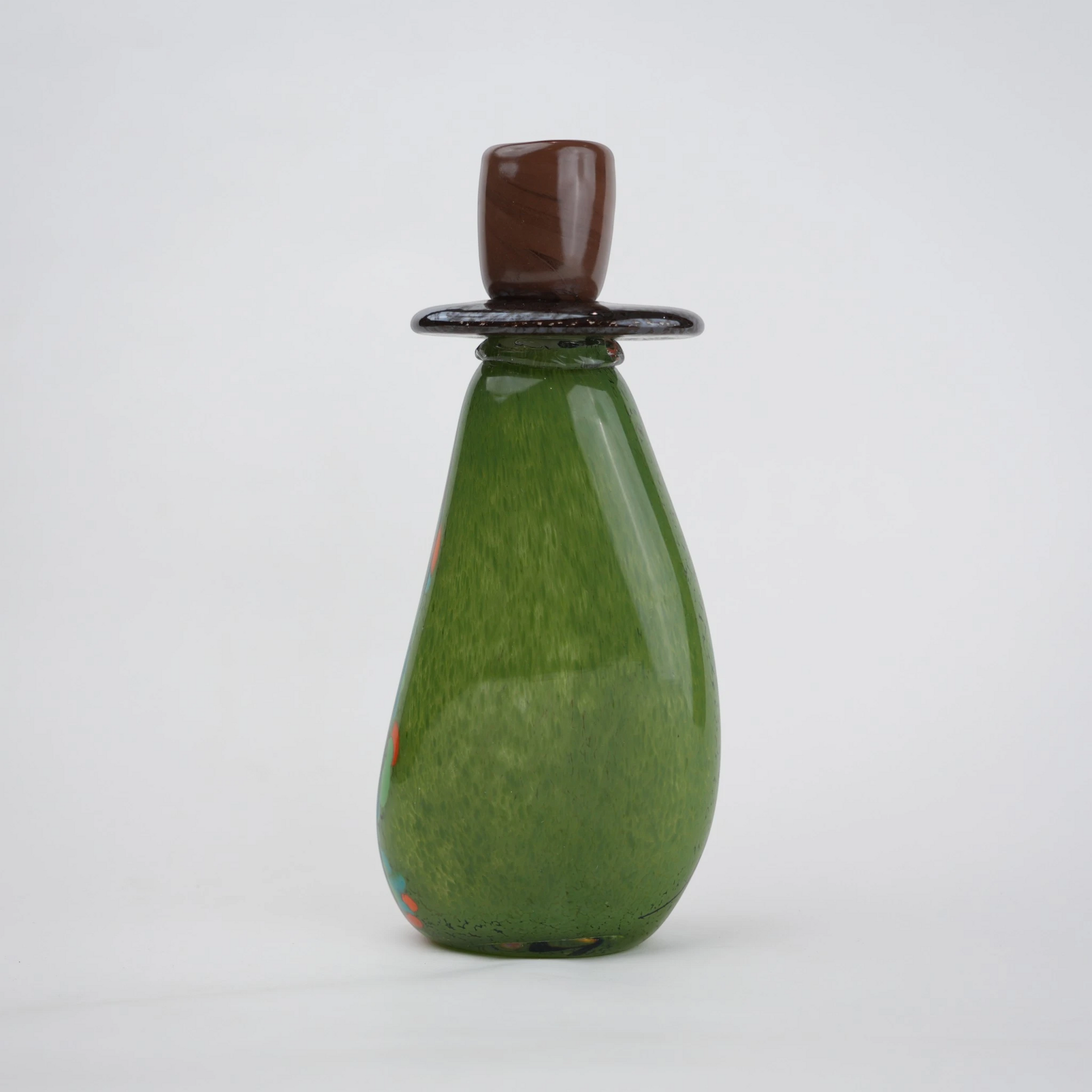 Emerald green decorative glass candle holder with orange and black drip pattern