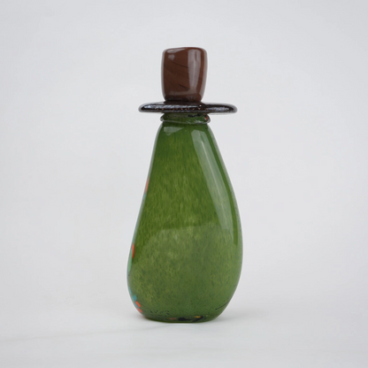 Emerald green decorative glass candle holder with orange and black drip pattern