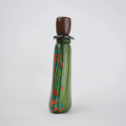 Emerald green decorative glass candle holder with orange and black drip pattern