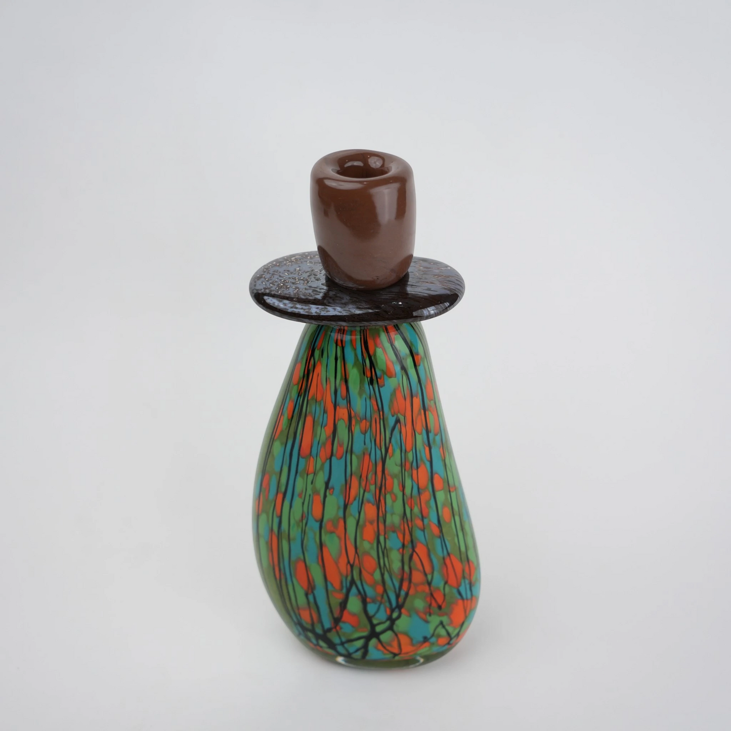 Emerald green decorative glass candle holder with orange and black drip pattern