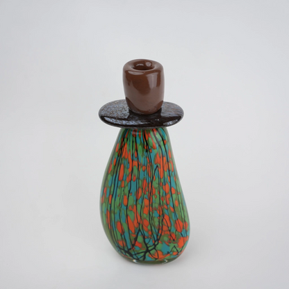 Emerald green decorative glass candle holder with orange and black drip pattern