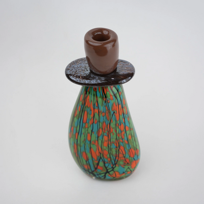 Emerald green decorative glass candle holder with orange and black drip pattern