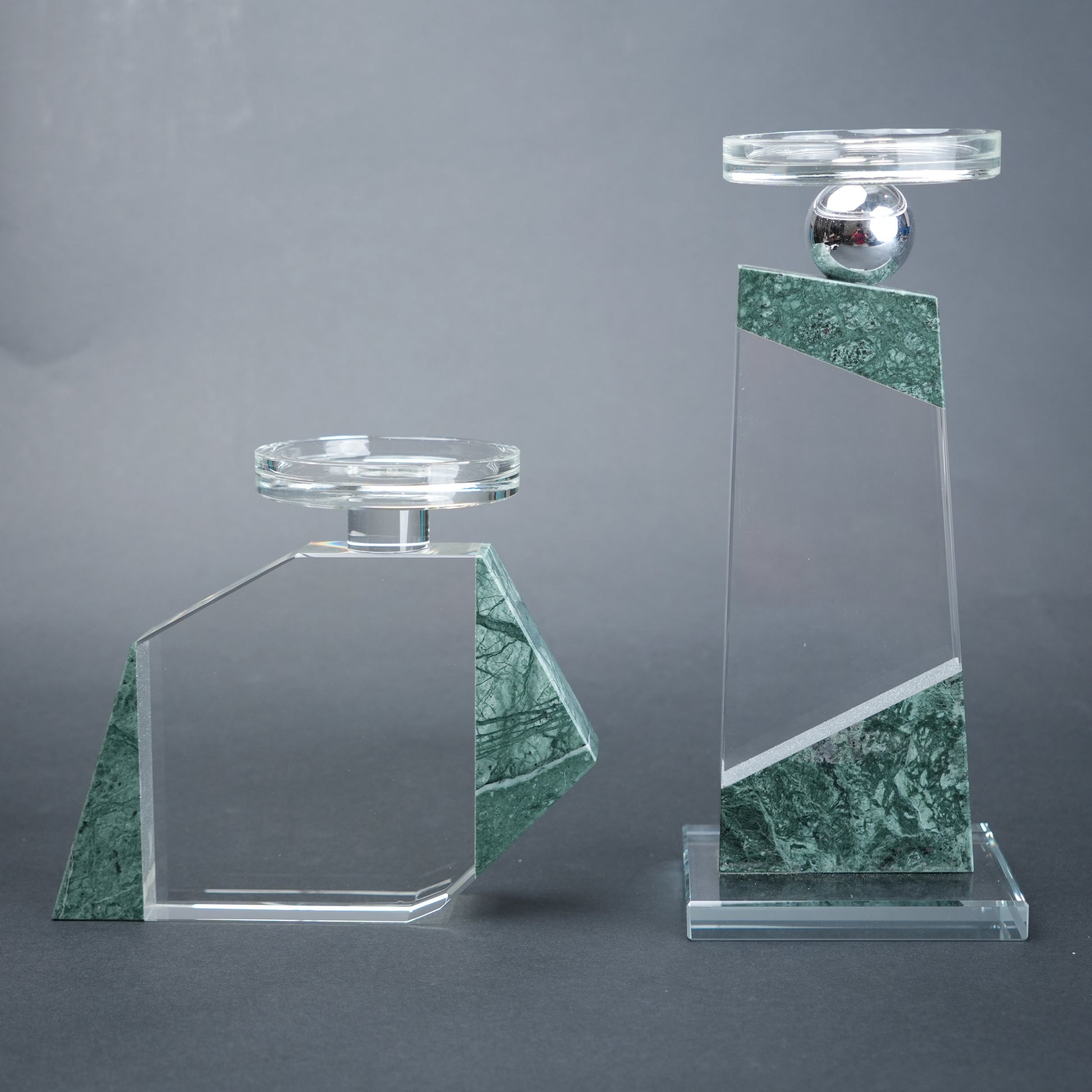 Two glass and marble decorative items on a gray background