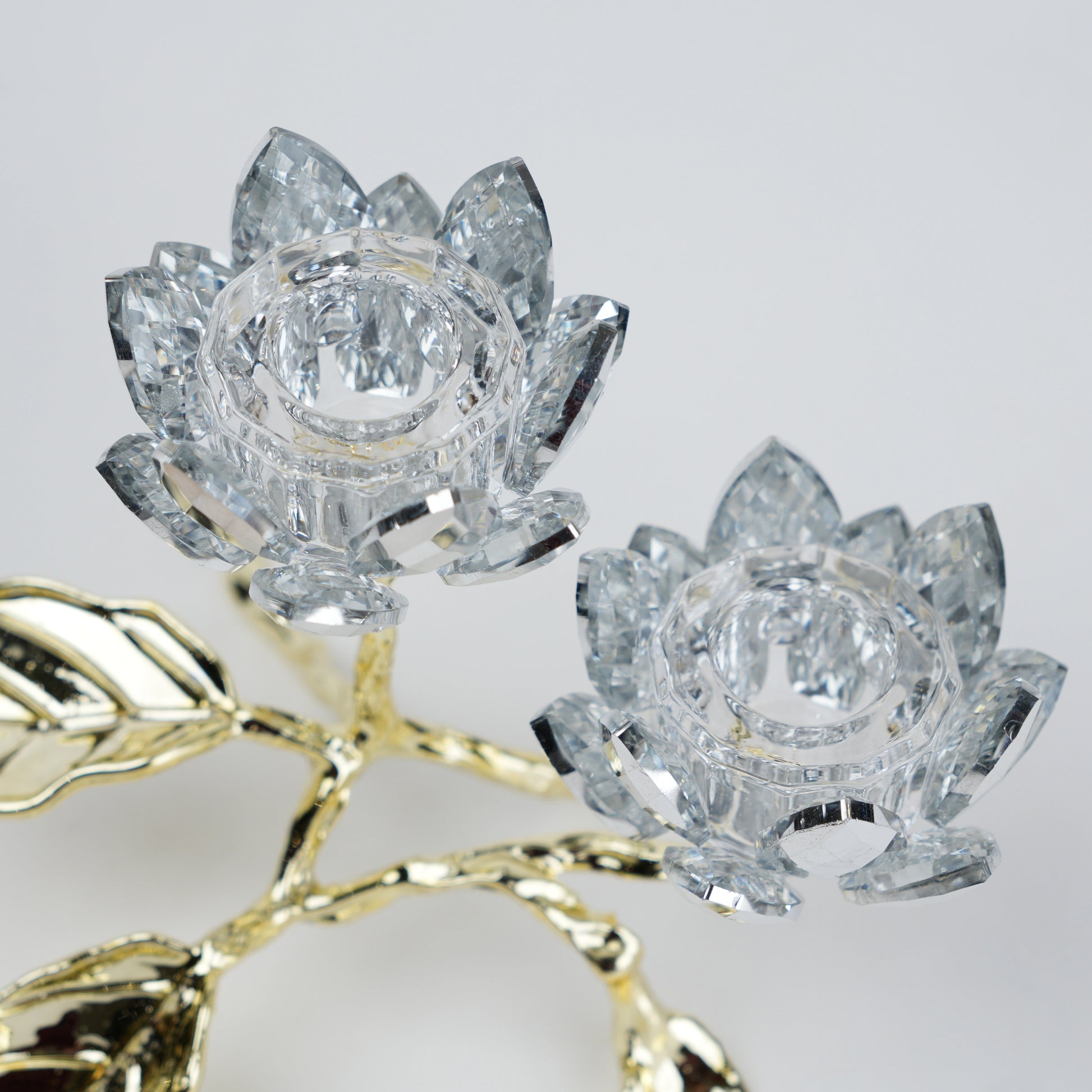 Crystal lotus flowers with gold stem on a light gray background