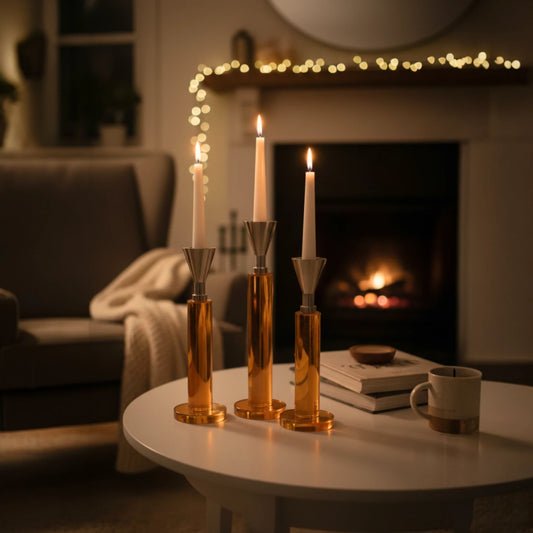Set of three amber glass column candle holders with metallic flared tops and modern sculptural design